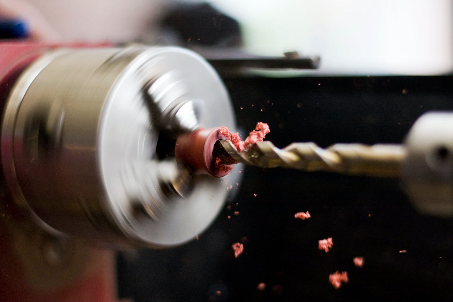 Lathe spinning while a drill bit is drilling into a wood ear plug. 